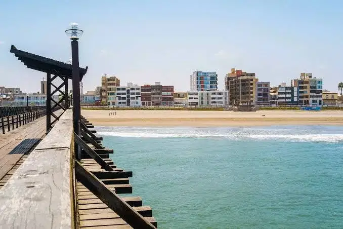 Muelle de madera de Pimentel con la playa y edificios frente al mar
